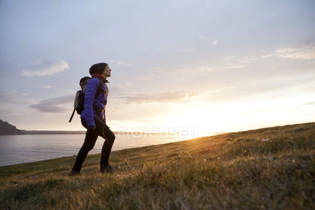 Islanda, donna che cammina al crepuscolo su una collina — Foto stock