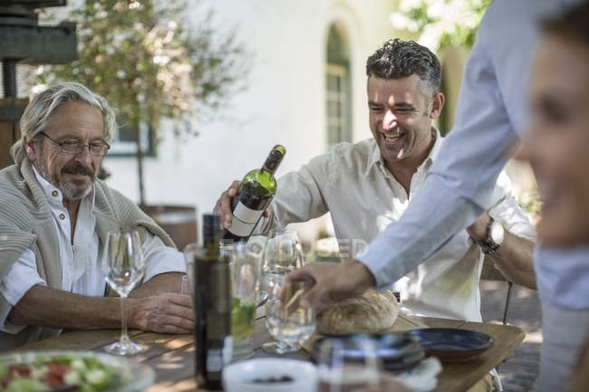 Padre e hijo tomando vino disfrutando de un almuerzo familiar juntos —  padres, exterior - Stock Photo | #173618758