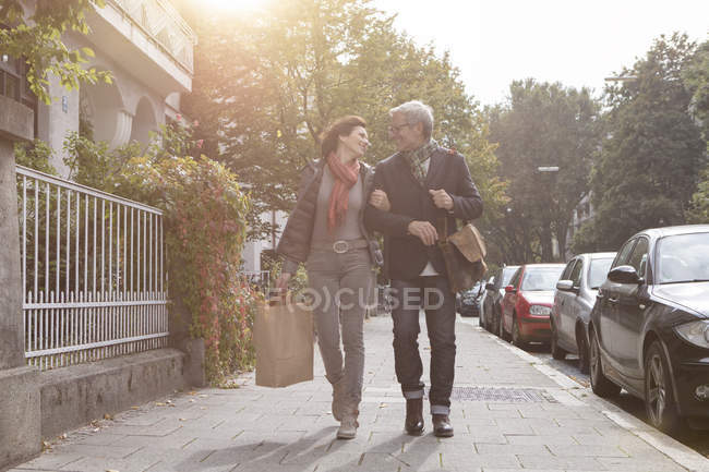 Усміхаючись Літня пара, йдучи по тротуару в місті — стокове фото