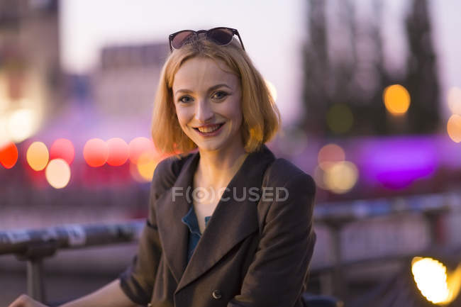 Retrato de jovem mulher loira atraente contra fundo borrado — Fotografia de Stock