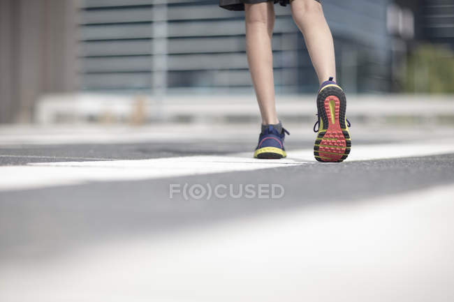 Ноги мальчика в спортивной обуви прогулки по городу — стоковое фото