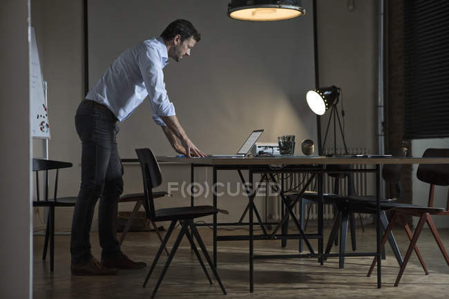 Geschäftsmann arbeitet spät im Büro mit Laptop — Stockfoto