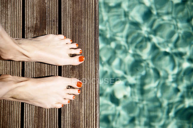 Женские ноги стоят на краю бассейна — стоковое фото