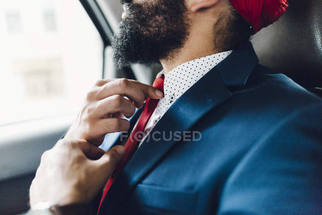 Indischer Geschäftsmann berührt Krawatte im Taxi — Stockfoto