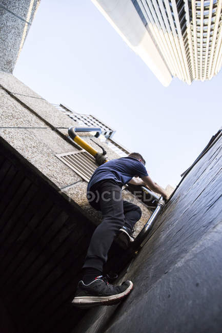 Espagne, Madrid, homme grimpant sur un mur dans la ville lors d'une session de parkour — Photo de stock