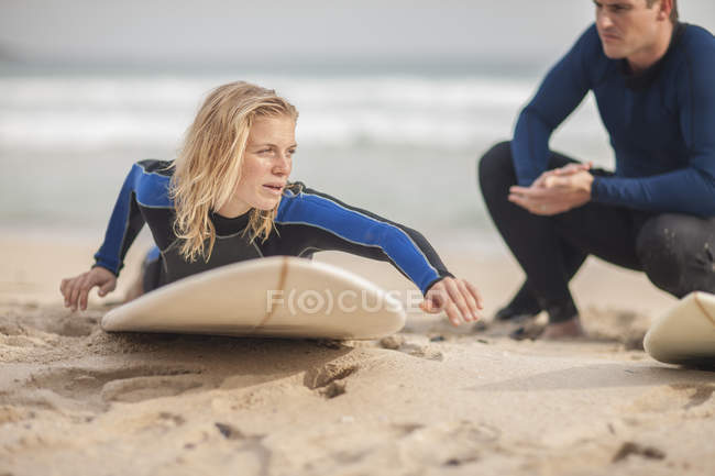 Uomo istruire donna sulla tavola da surf — Foto stock