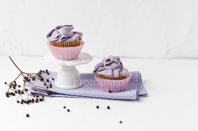 Dos cupcakes con crema de flor de saúco en la servilleta - foto de stock