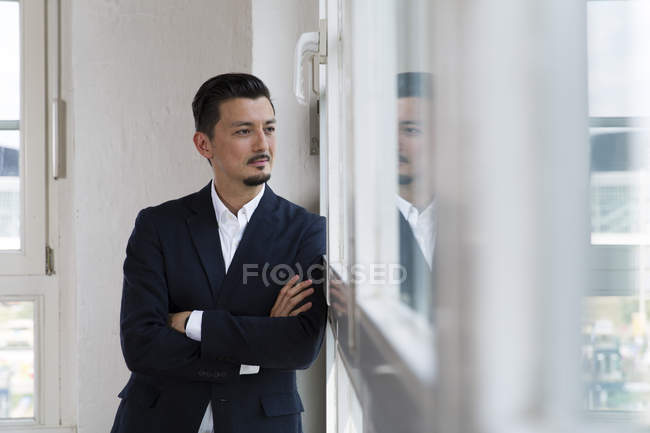 Empresário de pé na janela — Fotografia de Stock
