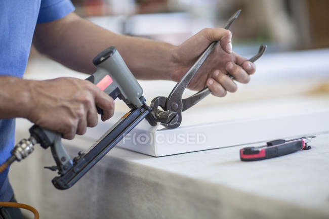 Man working on frame in canvas workshop — Stock Photo