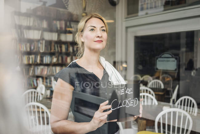 Frau in Café mit verschlossenem Schild — Stockfoto