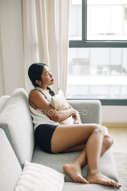 Женщина лежит на диване с подушкой — Мышление, Вид сбоку - Stock Photo