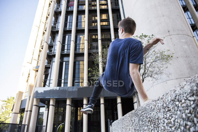 Spagna, Madrid, uomo che salta da un muro in città durante una sessione di parkour — Foto stock