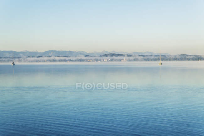 Alemania, Alta Baviera, vista al lago Starnberg con neblina temprano en la mañana - foto de stock