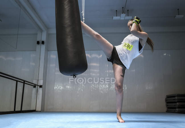 Молодая женщина кикбоксинг в спортзале — стоковое фото