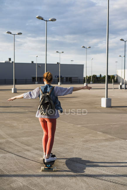 Giovane donna sullo skateboard al livello del parcheggio — Foto stock
