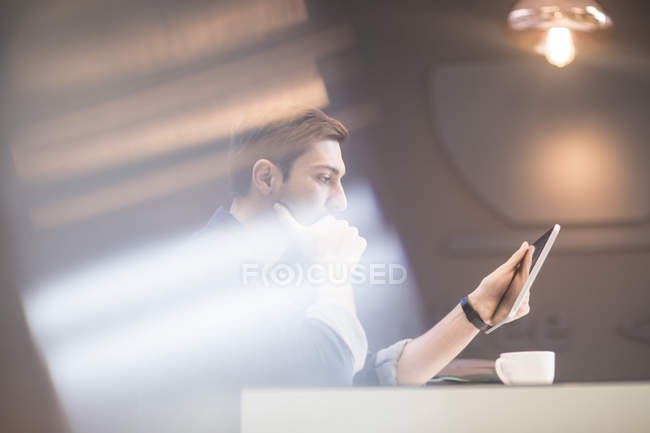 Uomo con tablet digitale alla scrivania pensando — Foto stock