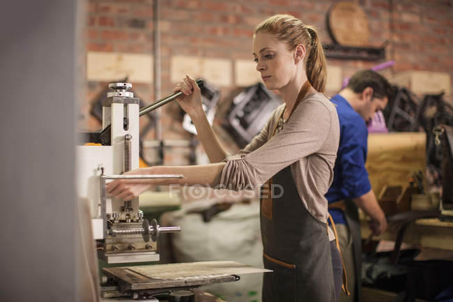 Junge Frau arbeitet in Lederwerkstatt — Stockfoto