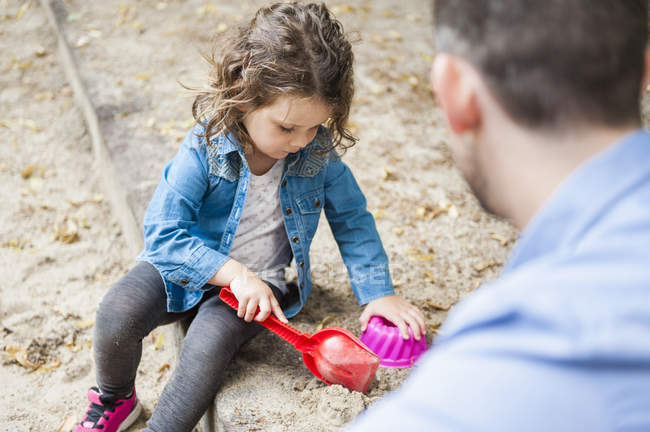 Pai brincando com a filha em sandbox — Fotografia de Stock