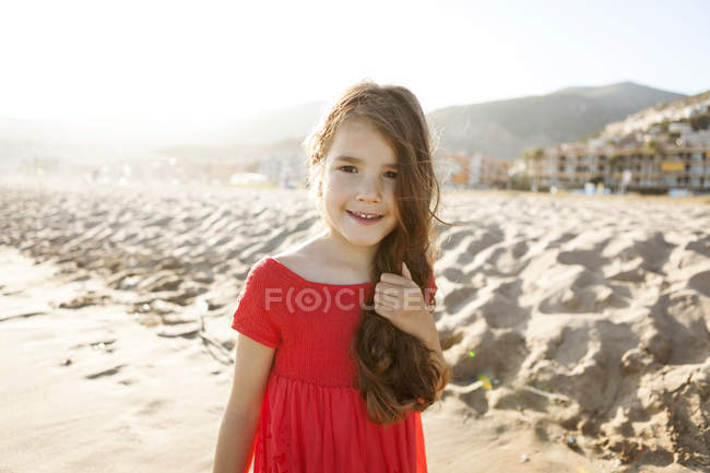 Портрет улыбающейся маленькой девочки на пляже — стоковое фото