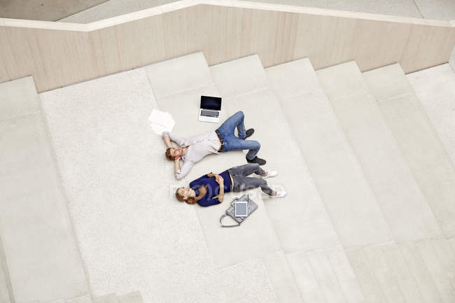 Man and woman lying on staircase — Stock Photo