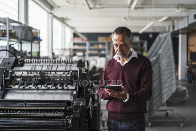 Reifer Mann in einer Druckerei — Stockfoto