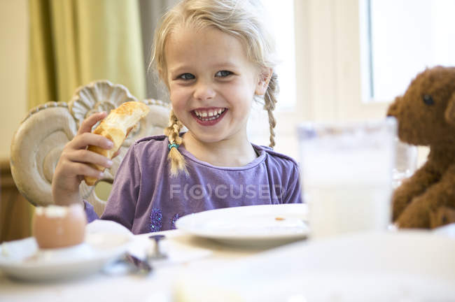 Retrato de menina loira feliz na mesa de café da manhã — Fotografia de Stock