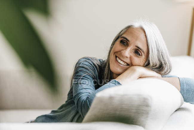 Femme souriante sur le canapé — Photo de stock