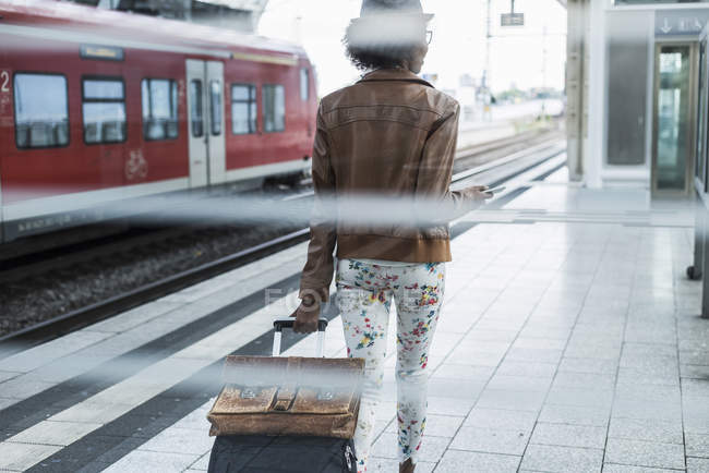 Donna con borsa trolley e valigetta che cammina sulla piattaforma — Foto stock