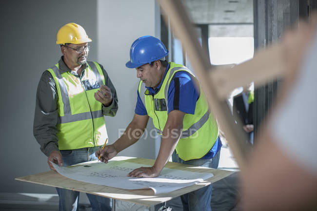 Two construction workers talking on construction site — Stock Photo