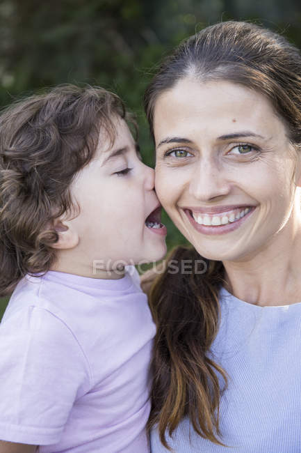 Portrait of happy mother with little daughter kissing her — Stock Photo