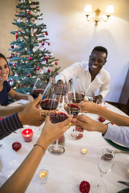Amici brindare con il vino durante la cena di Natale — Foto stock