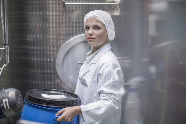 Técnico de laboratorio en planta farmacéutica frente a tanques - foto de stock