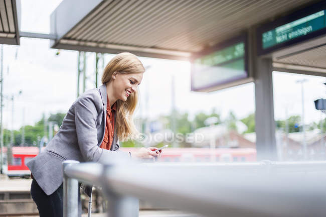 Young woman looking on cell phone — Stock Photo