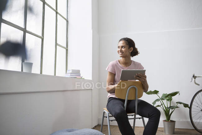 Frau sitzt mit digitalem Tablet im Stuhl — Stockfoto