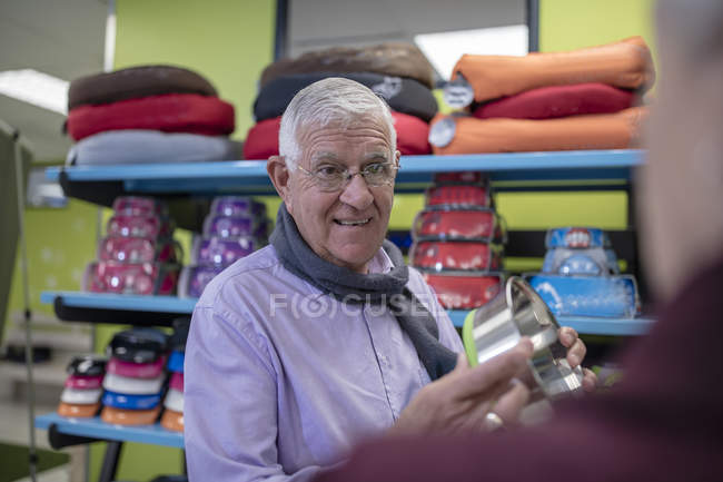 Hombre mayor de compras en una tienda de mascotas elegir tazón - foto de stock