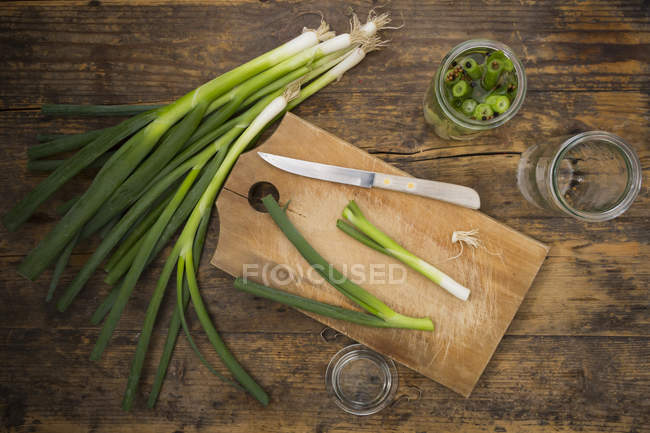 Eingelegte Frühlingszwiebeln auf dem Holzbrett — Stockfoto