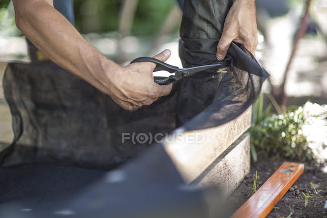 Fecho do homem que aplica folha metálica à caixa durante o dia — Fotografia de Stock