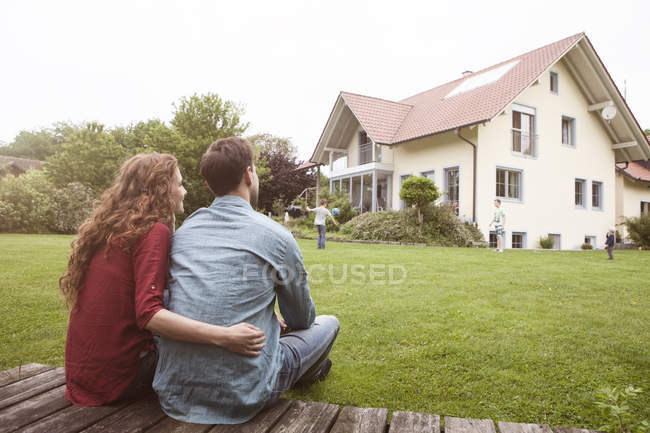 Couple in garden looking at house — Stock Photo