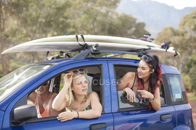 Friends on a trip in car with surfboards — Stock Photo