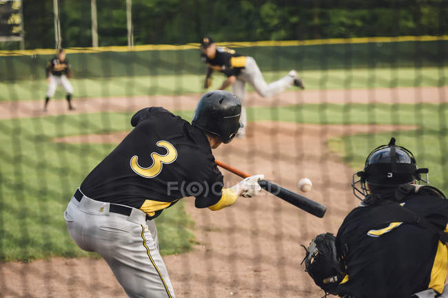 Baseballspieler schlägt Ball auf Feld — Stockfoto