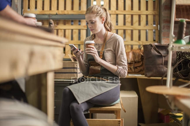 Jeune femme ayant une pause dans l'atelier de cuir — Photo de stock