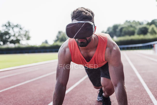 Atleta en pista de tartán con gafas de realidad virtual - foto de stock