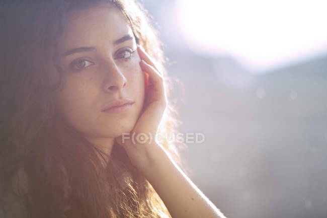 Portrait of young woman at a window — Stock Photo