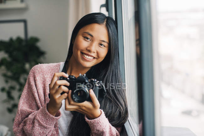 Жінка з камерою, дивлячись на камеру — стокове фото