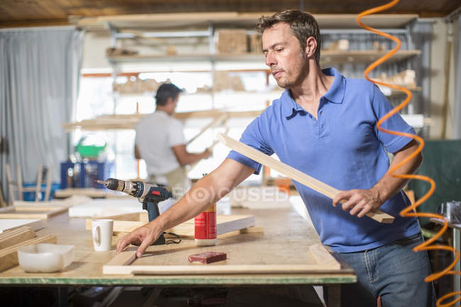 Zwei Männer, die in der Leinwandwerkstatt arbeiten — Stockfoto