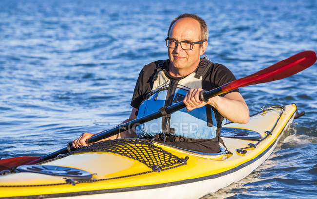 Uomo anziano remare sul kayak — Foto stock