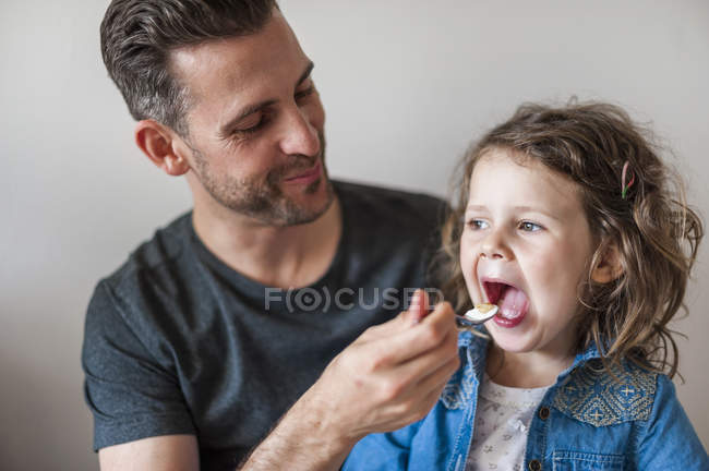 Father feeding his daughter — Stock Photo