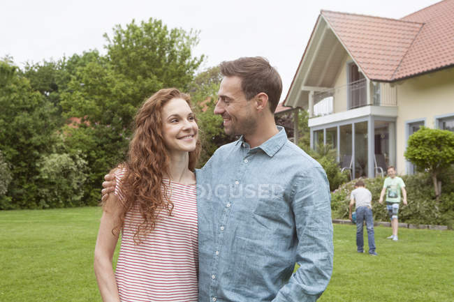 Couple in garden with kids — Stock Photo
