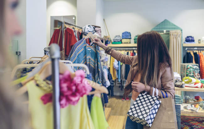 Woman shopping for clothes in a boutique — Stock Photo