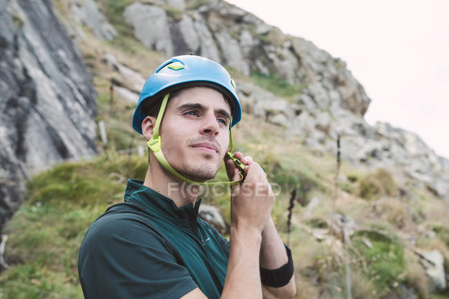 Giovane uomo che indossa il casco da arrampicata — Foto stock